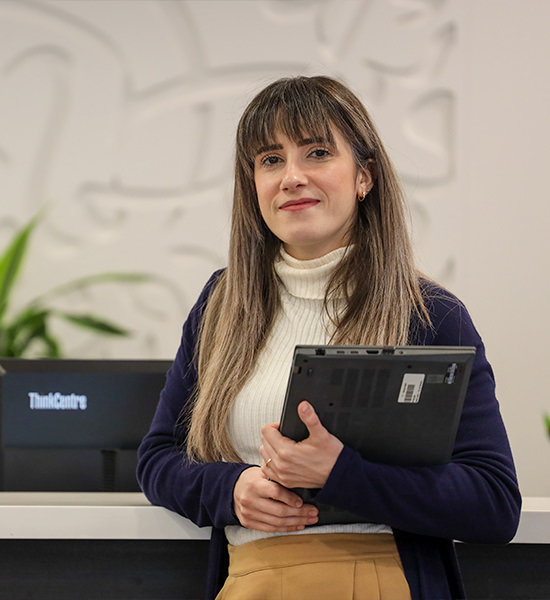 A woman is holding a laptop