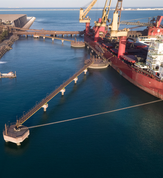 A large cargo ship is moored off the coast of a Factory